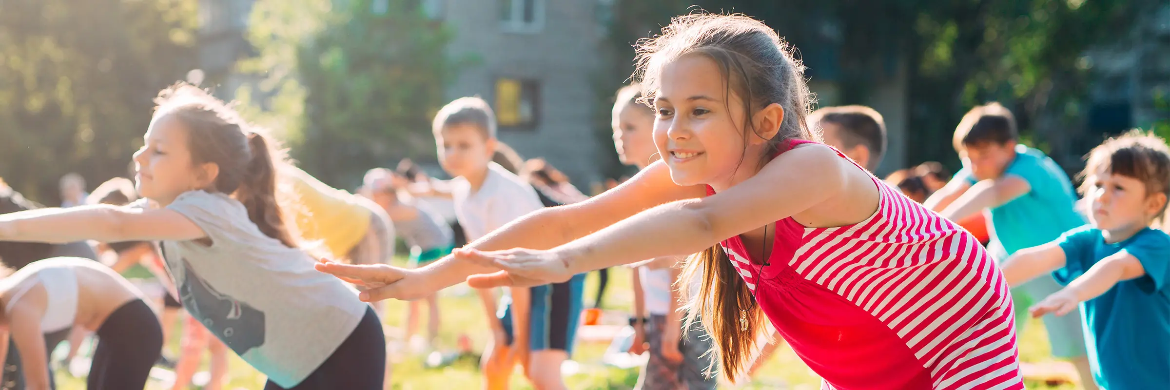 Barn som gör yoga tillsammans på en gräsmatta